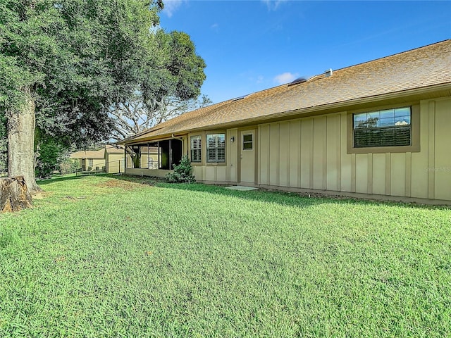 rear view of house featuring a lawn