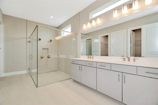 bathroom with tile patterned flooring, vanity, and walk in shower