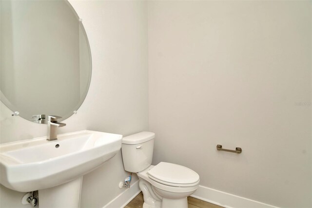 bathroom with sink, toilet, and hardwood / wood-style flooring