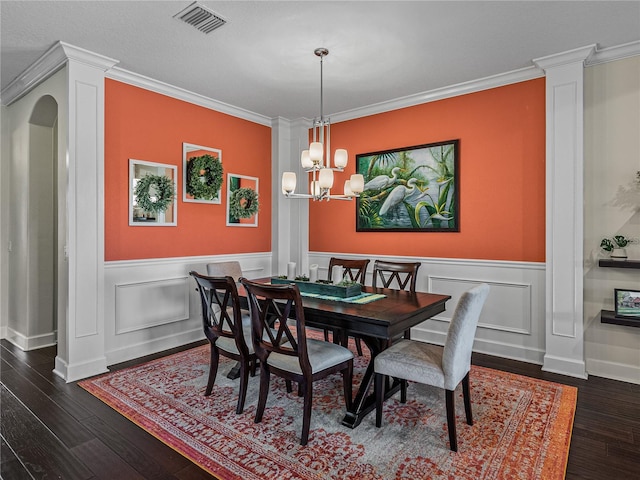 dining room with ornamental molding, an inviting chandelier, and dark hardwood / wood-style floors