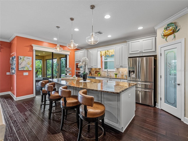 kitchen featuring tasteful backsplash, a kitchen island, dark hardwood / wood-style floors, stainless steel refrigerator with ice dispenser, and white cabinets