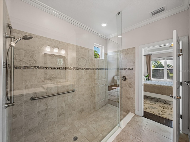 bathroom with tiled shower, crown molding, and tile patterned floors