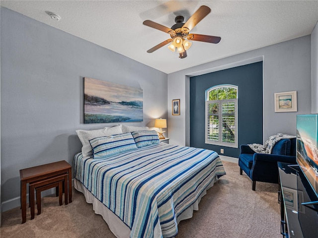 bedroom with a textured ceiling, carpet flooring, and ceiling fan