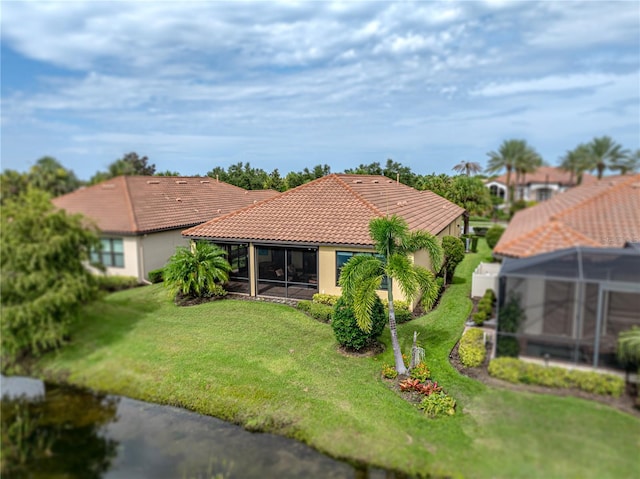 rear view of property with a lawn and a sunroom