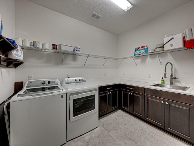 washroom featuring cabinets, separate washer and dryer, a textured ceiling, light tile patterned floors, and sink