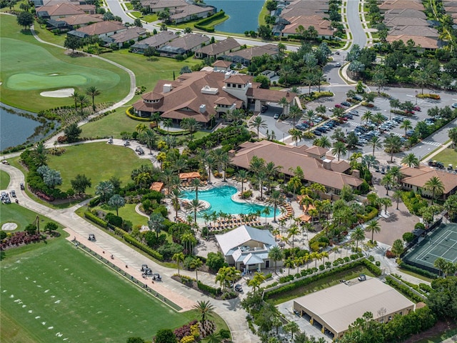 drone / aerial view featuring a water view, view of golf course, and a residential view
