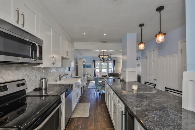 kitchen featuring decorative backsplash, dark hardwood / wood-style floors, white cabinets, appliances with stainless steel finishes, and sink