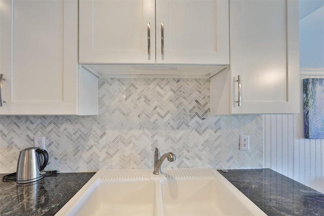 kitchen featuring backsplash, white cabinets, and sink