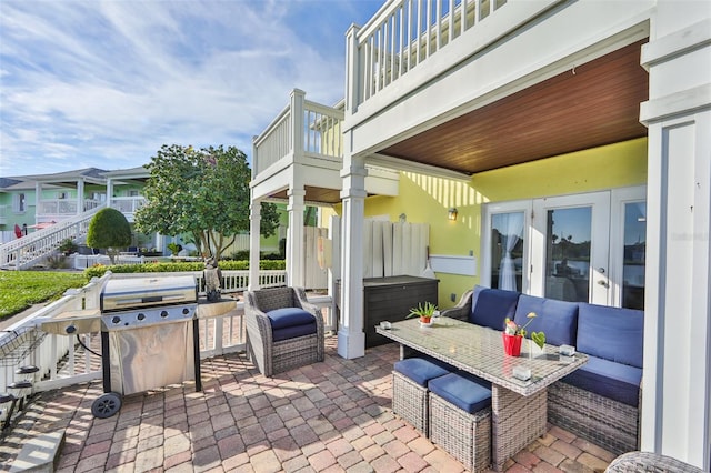 view of patio with a balcony, french doors, and a grill