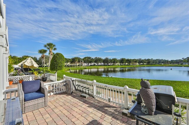 deck featuring a lawn, a water view, and a patio