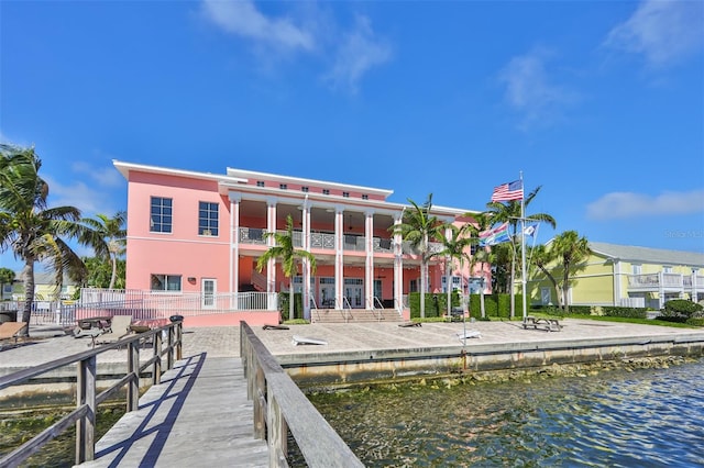 dock area with a balcony and a water view