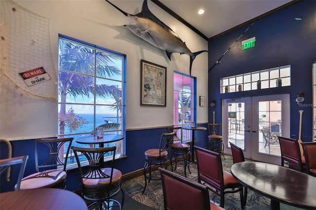 office space with vaulted ceiling, a water view, and french doors