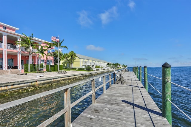 dock area with a balcony and a water view