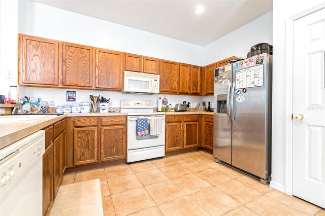 kitchen featuring sink, white appliances, and light tile patterned floors