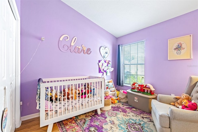 bedroom featuring hardwood / wood-style floors and a nursery area