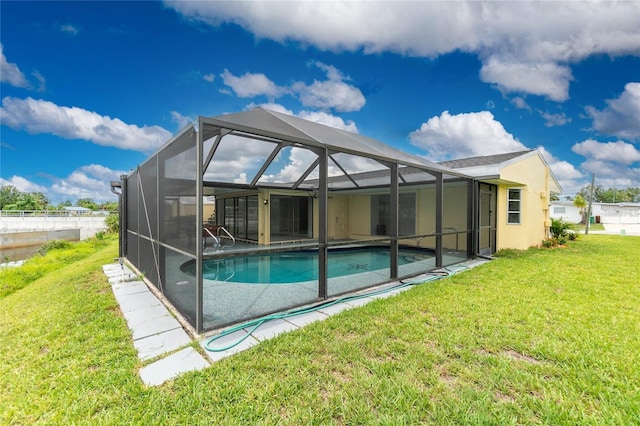 view of swimming pool with a lawn and a lanai