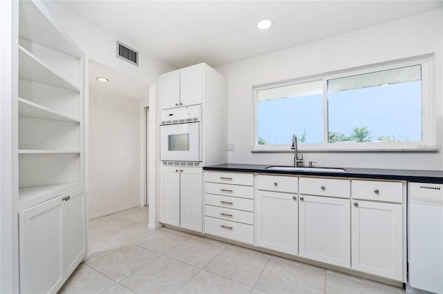 kitchen featuring sink, white appliances, white cabinets, and light tile patterned floors