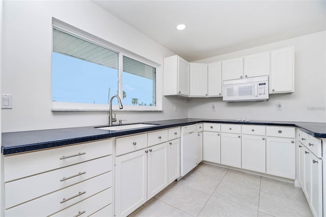 kitchen featuring sink, white cabinets, white appliances, and light tile patterned floors