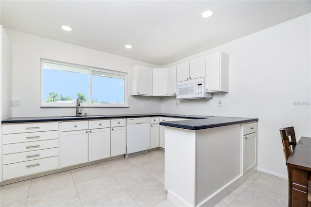 kitchen with light tile patterned floors, sink, white appliances, white cabinetry, and kitchen peninsula