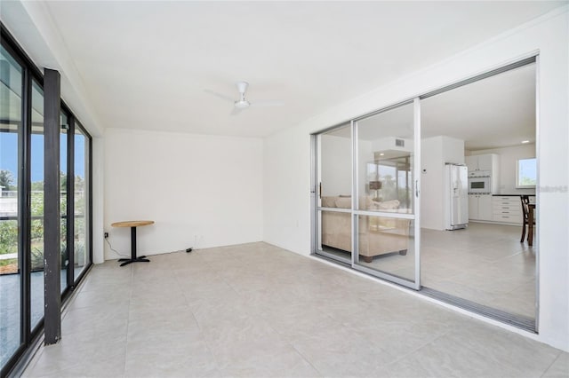 tiled spare room with ceiling fan