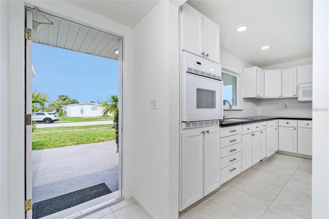 kitchen with a wealth of natural light, sink, white cabinetry, and white appliances