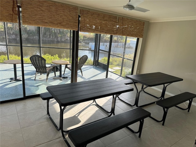 interior space with light tile patterned flooring, ceiling fan, and a water view