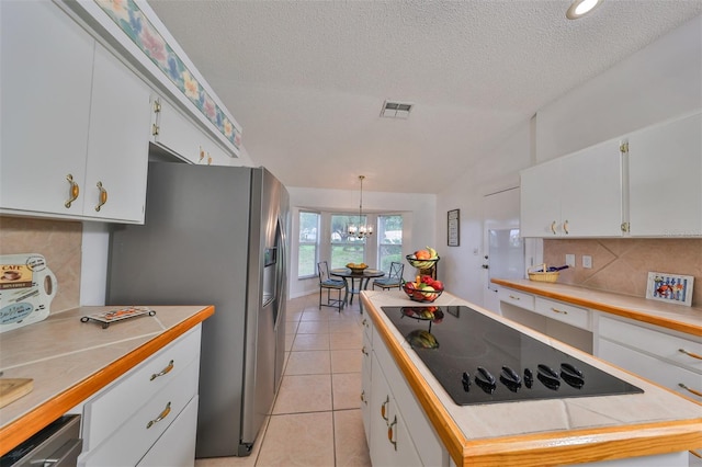 902 Mcdaniel St Unit 1, Sun City Center, FL 33573 - kitchen featuring black electric cooktop, lofted ceiling, stainless steel fridge with ice dispenser, backsplash, and light countertops