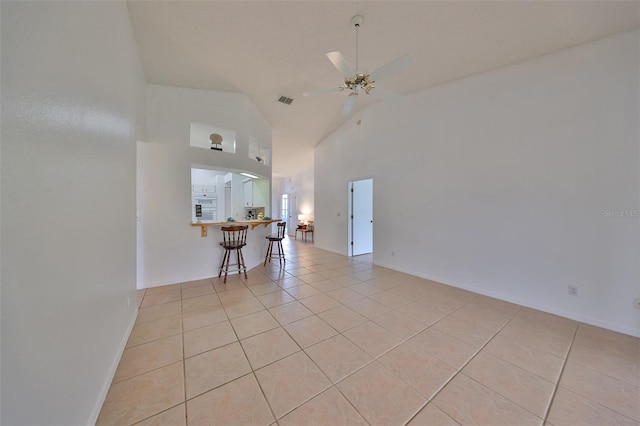 unfurnished room with ceiling fan, high vaulted ceiling, and light tile patterned flooring