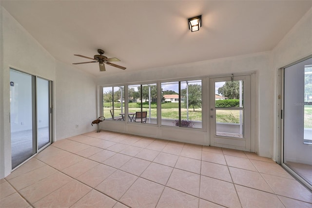 unfurnished sunroom featuring vaulted ceiling, ceiling fan, and plenty of natural light