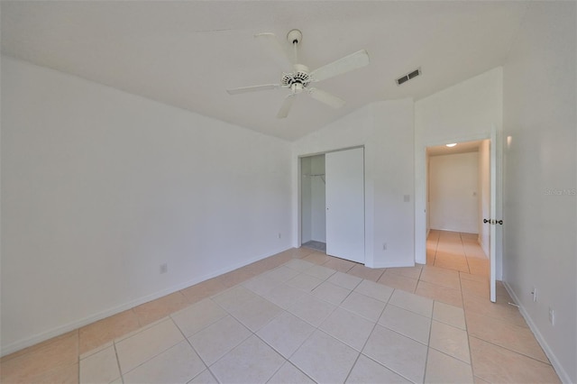 bedroom featuring a closet, ceiling fan, light tile patterned floors, and vaulted ceiling