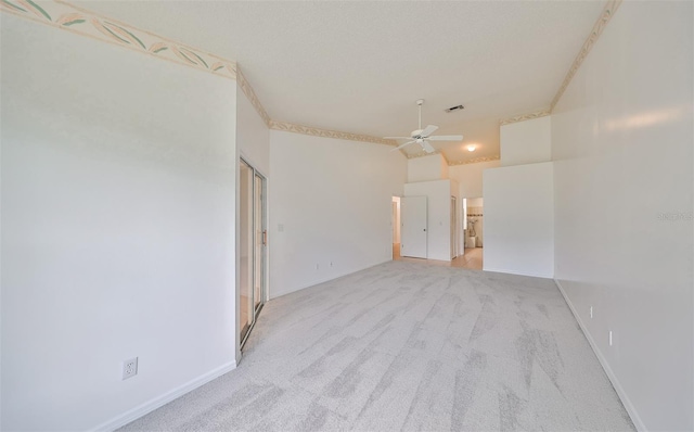 carpeted spare room featuring ceiling fan and a towering ceiling