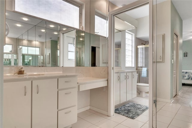 bathroom with tile patterned floors, vanity, walk in shower, and toilet