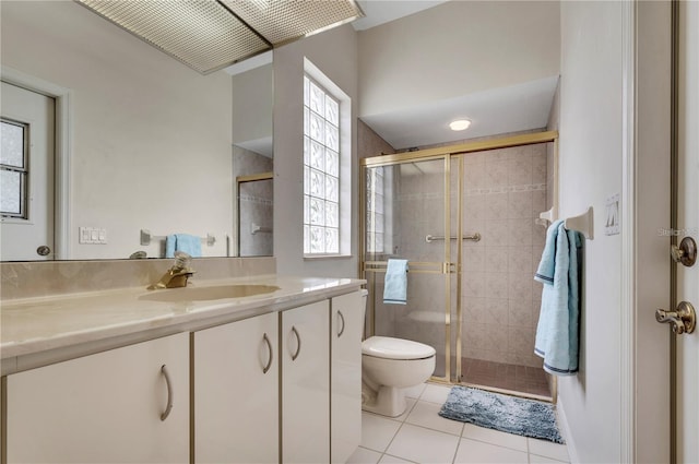 bathroom with a wealth of natural light, tile patterned flooring, vanity, and toilet