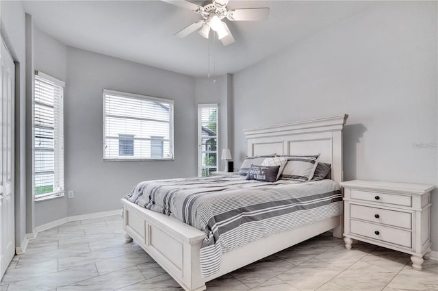 tiled bedroom with ceiling fan and multiple windows