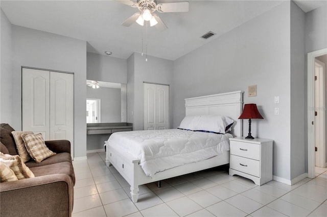 tiled bedroom featuring ceiling fan and two closets