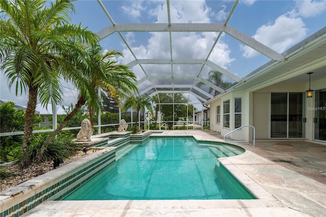 view of pool with glass enclosure and a patio area