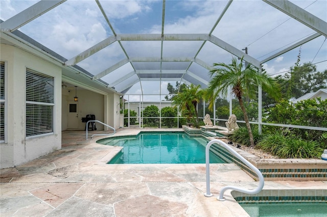 view of swimming pool with glass enclosure and a patio area