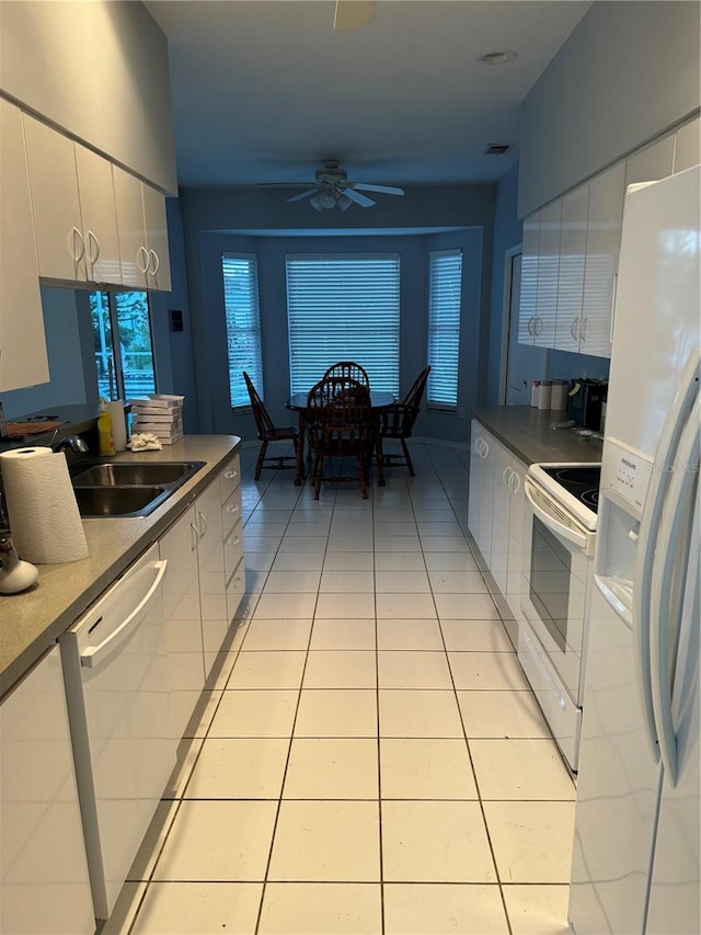 kitchen featuring light tile patterned flooring, sink, white appliances, ceiling fan, and white cabinetry