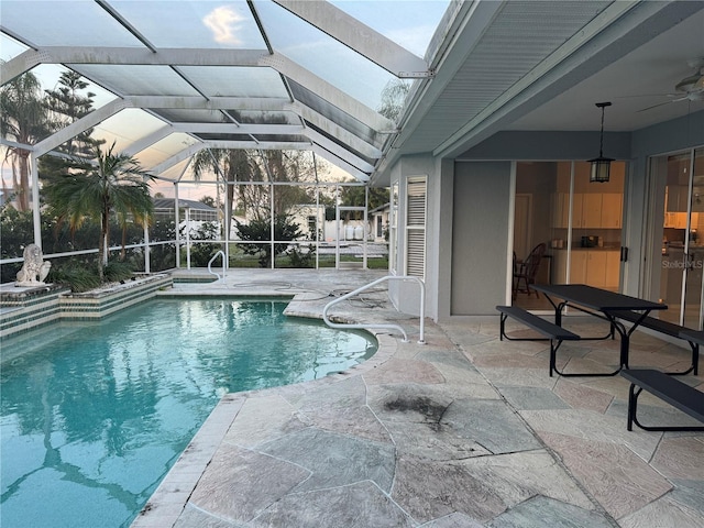 view of swimming pool featuring ceiling fan, a patio, and a lanai