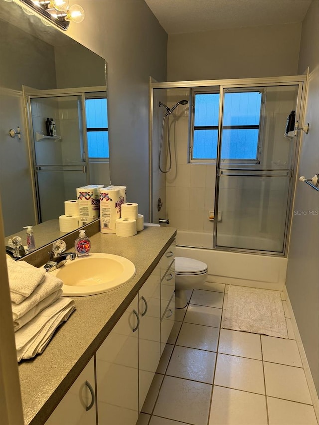 full bathroom featuring enclosed tub / shower combo, toilet, vanity, and tile patterned floors