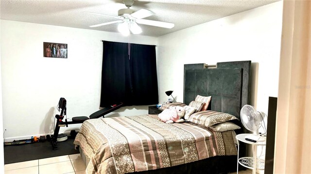 bedroom featuring a ceiling fan, a textured ceiling, and light tile patterned floors