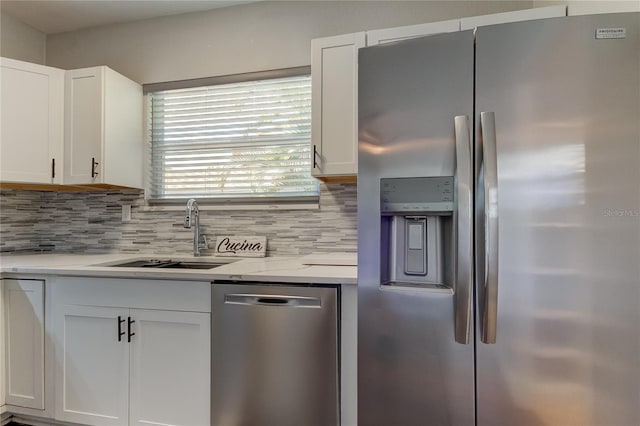 kitchen with white cabinetry, backsplash, stainless steel appliances, and light stone countertops