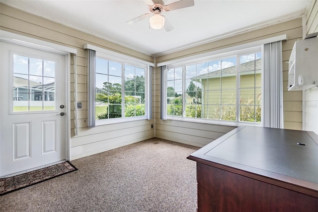 unfurnished sunroom featuring ceiling fan