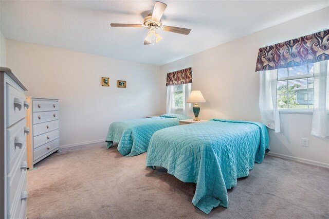 carpeted bedroom with ceiling fan and multiple windows