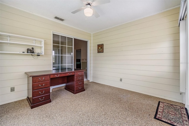 carpeted office space featuring ceiling fan