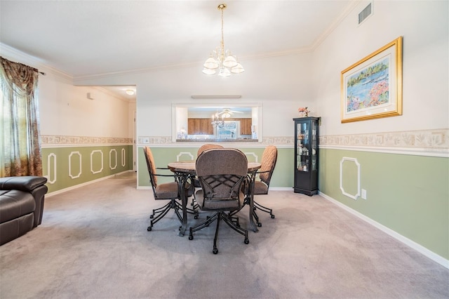 dining space with a notable chandelier, crown molding, and carpet flooring