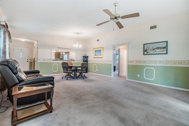 living room with ceiling fan with notable chandelier and crown molding