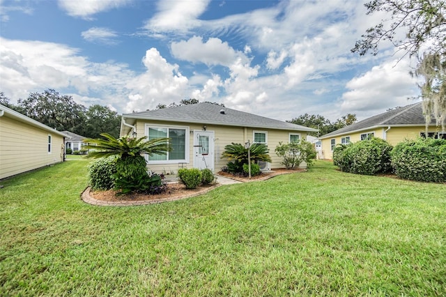 rear view of property with a yard