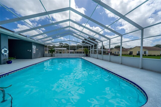 view of pool featuring glass enclosure and a patio area