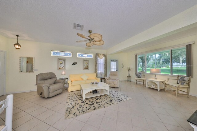 living room with light tile patterned floors, a textured ceiling, and ceiling fan